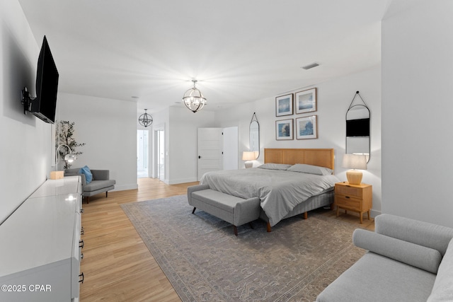 bedroom featuring light hardwood / wood-style flooring and a notable chandelier