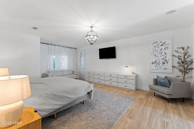 bedroom featuring a notable chandelier and light wood-type flooring