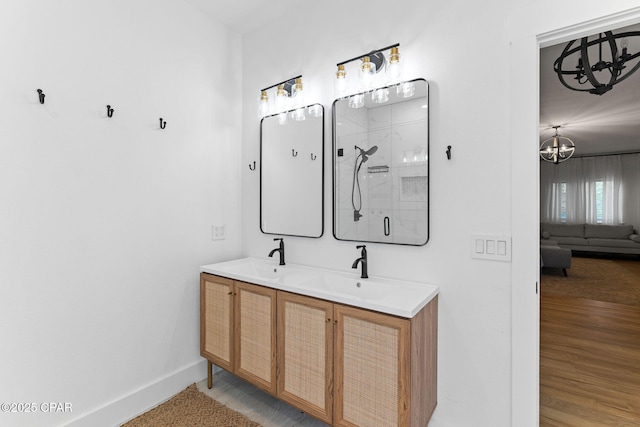 bathroom featuring vanity, an enclosed shower, and an inviting chandelier