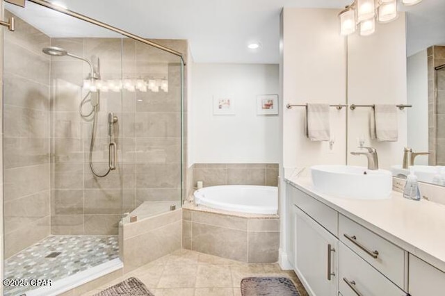 bathroom featuring shower with separate bathtub, vanity, and tile patterned floors