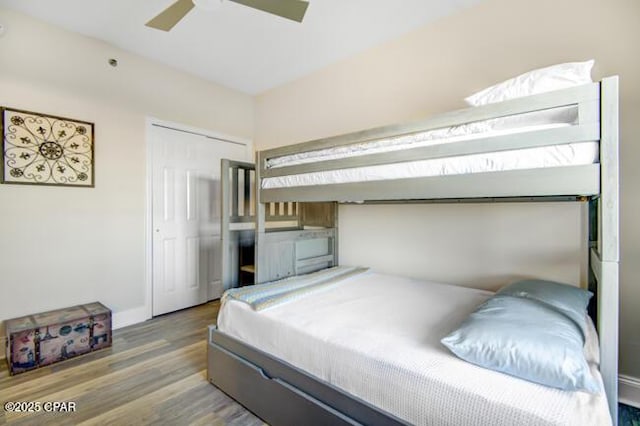 bedroom with hardwood / wood-style floors, ceiling fan, and a closet