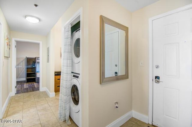 laundry room with light tile patterned floors and stacked washer and dryer