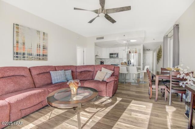 living room featuring ceiling fan and wood-type flooring