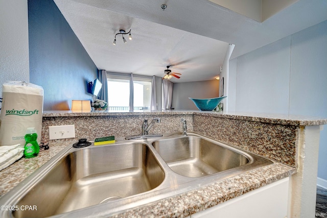 details with ceiling fan, sink, and a textured ceiling