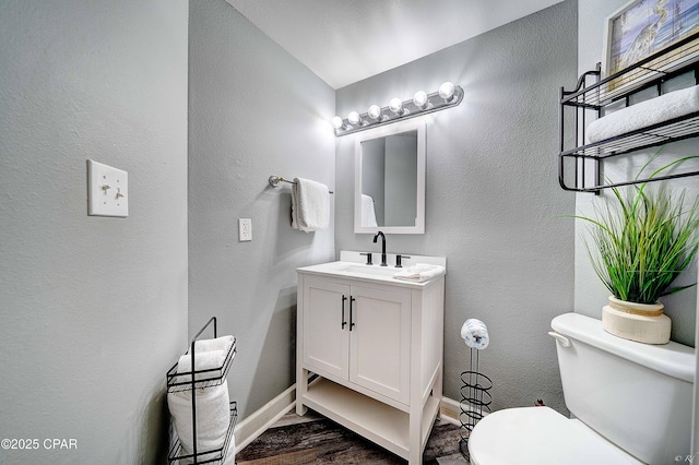 bathroom featuring wood-type flooring, vanity, and toilet