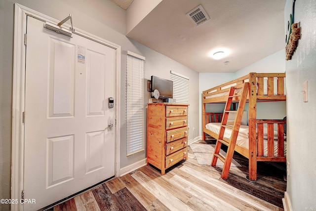 bedroom featuring wood-type flooring and a textured ceiling