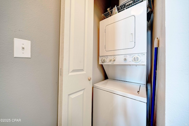 laundry room featuring stacked washer / drying machine