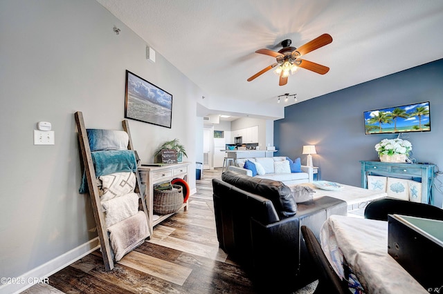 living room featuring ceiling fan, track lighting, a textured ceiling, and light hardwood / wood-style floors