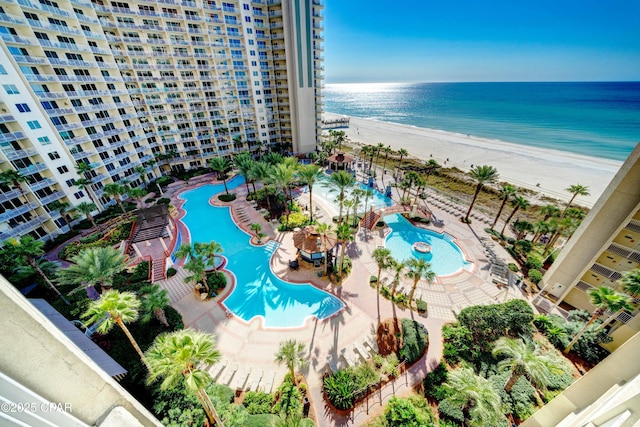 birds eye view of property with a water view and a beach view