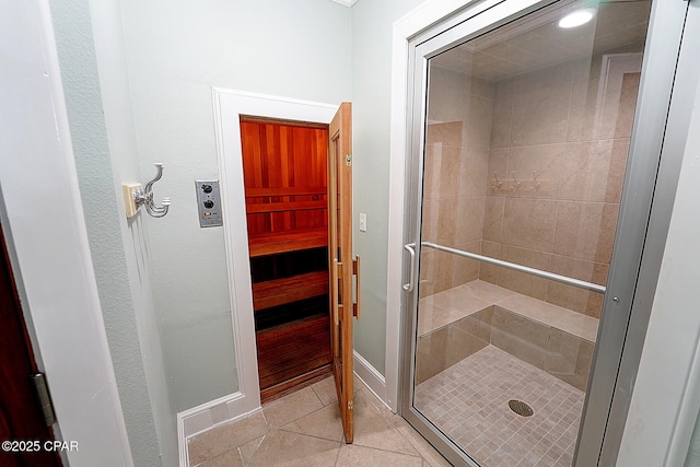 bathroom with a shower with door and tile patterned floors