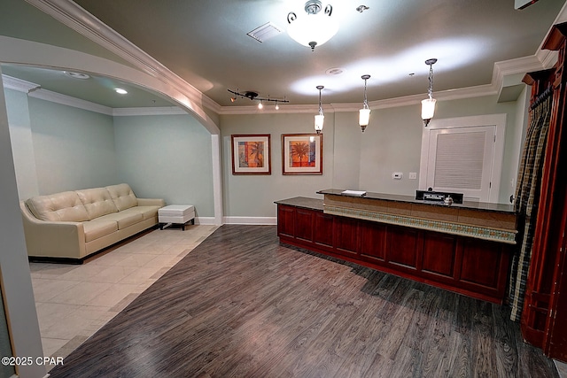 interior space with light wood-type flooring, pendant lighting, crown molding, and track lighting