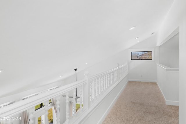 corridor with baseboards, carpet floors, and lofted ceiling