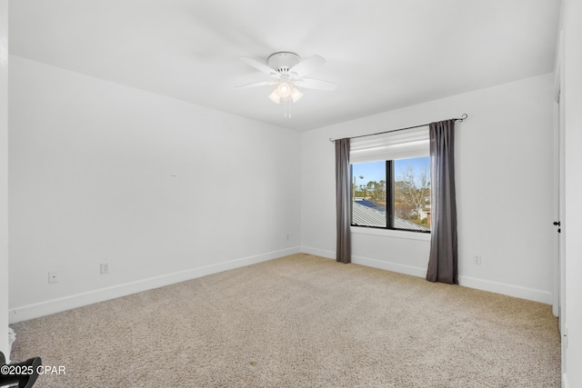 carpeted spare room with baseboards and ceiling fan