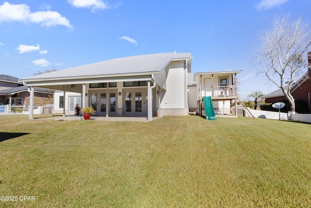 back of house featuring metal roof, a lawn, a patio area, and fence