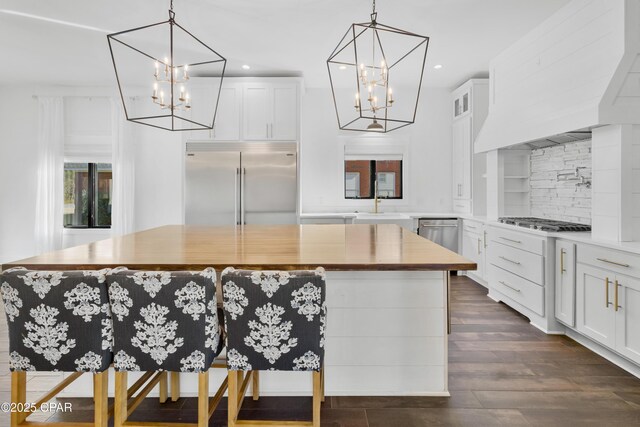 kitchen featuring white cabinetry, a notable chandelier, appliances with stainless steel finishes, and a center island