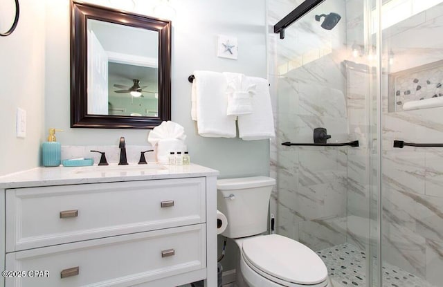 bathroom featuring vanity, toilet, an enclosed shower, and ceiling fan