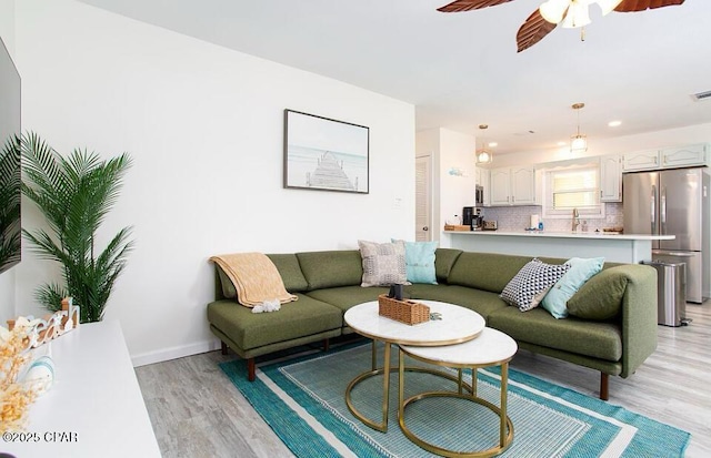 living room featuring ceiling fan and light hardwood / wood-style floors