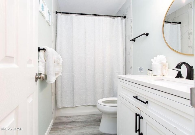 full bathroom with hardwood / wood-style flooring, vanity, toilet, and shower / tub combo