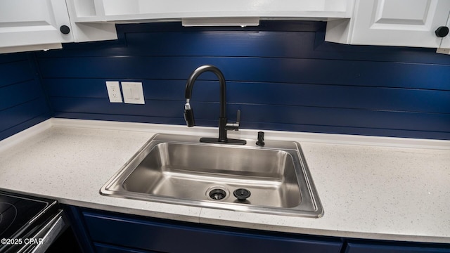 room details with sink, white cabinets, and blue cabinetry