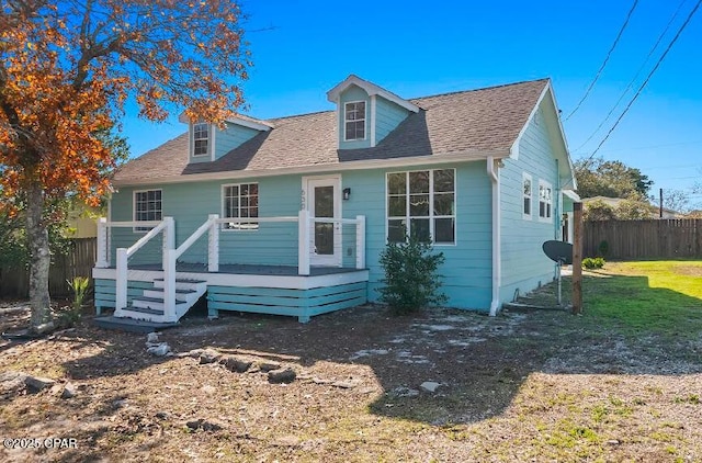 view of front of property with a wooden deck and a front lawn