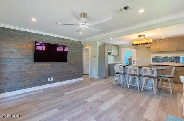 kitchen with a kitchen breakfast bar, ornamental molding, and a kitchen island