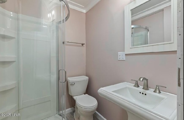 bathroom featuring toilet, an enclosed shower, and sink