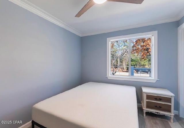 bedroom featuring ceiling fan, wood-type flooring, and ornamental molding