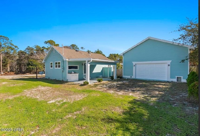 back of property with a garage and a yard