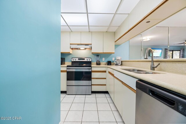 kitchen featuring stainless steel appliances, ceiling fan, sink, white cabinetry, and range hood