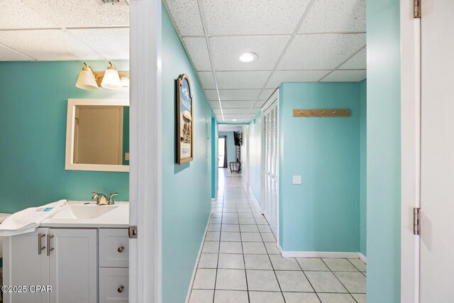 corridor with light tile patterned flooring and sink