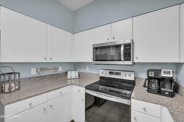 kitchen featuring appliances with stainless steel finishes, white cabinetry, and tile patterned flooring