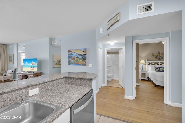 kitchen with stainless steel dishwasher, light tile patterned floors, and sink