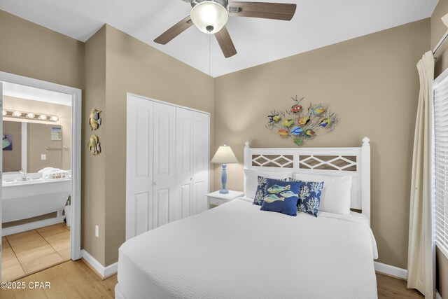 bedroom featuring ensuite bathroom, hardwood / wood-style floors, a closet, and ceiling fan