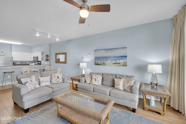 living room with ceiling fan and light wood-type flooring