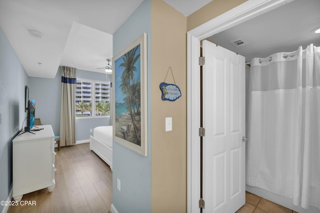 bathroom with shower / tub combo, wood-type flooring, and ceiling fan