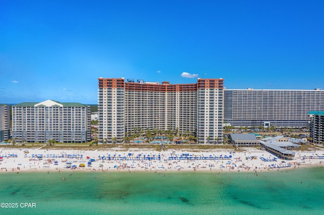 view of building exterior with a water view and a view of the beach