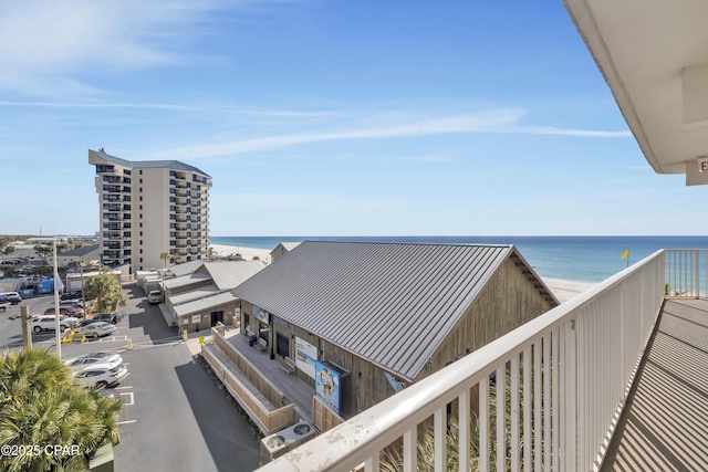 balcony featuring a beach view and a water view