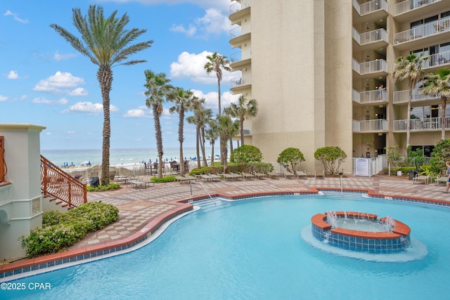 view of swimming pool with a patio and a water view