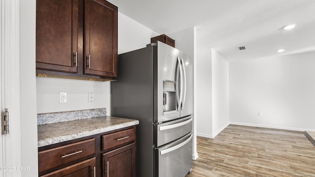 kitchen with stainless steel refrigerator with ice dispenser, dark brown cabinetry, and light hardwood / wood-style floors