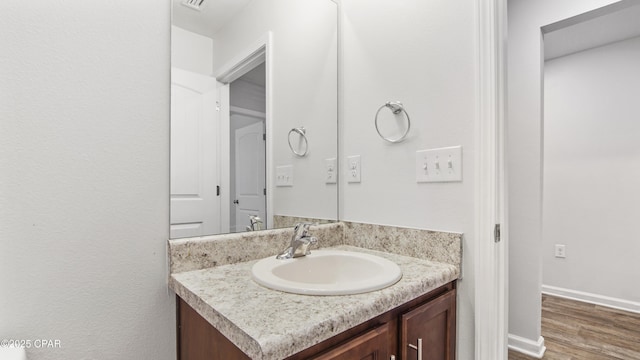 bathroom with hardwood / wood-style flooring and vanity