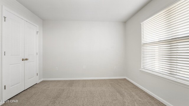 unfurnished bedroom with multiple windows, a closet, and carpet