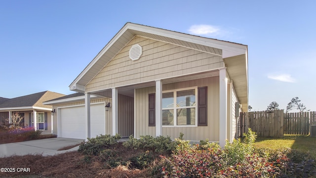 view of front facade with cooling unit, a garage, and a porch