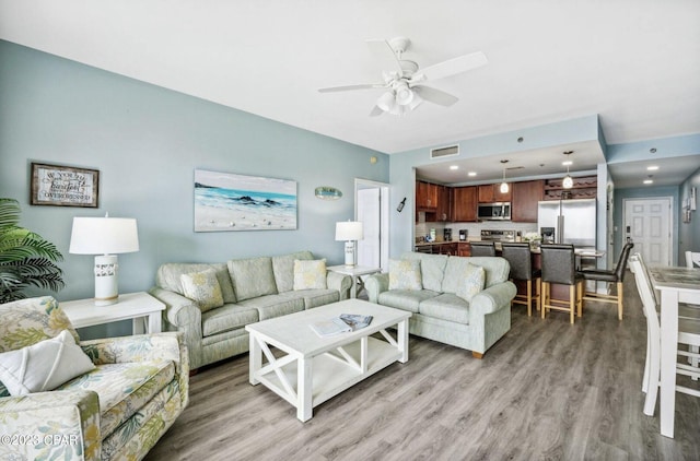 living room featuring light hardwood / wood-style floors and ceiling fan