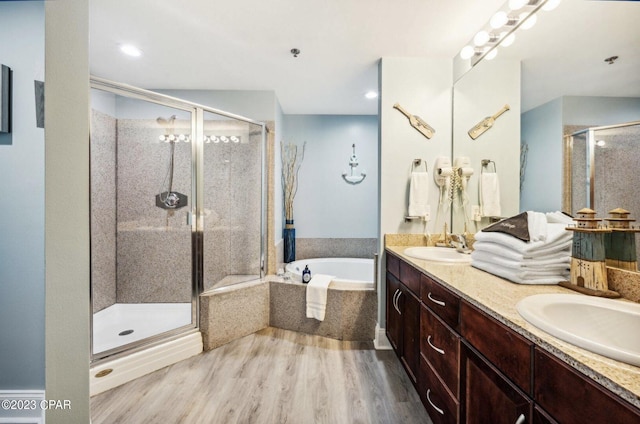 bathroom featuring hardwood / wood-style flooring, vanity, and shower with separate bathtub