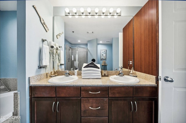 bathroom featuring a shower with door and vanity