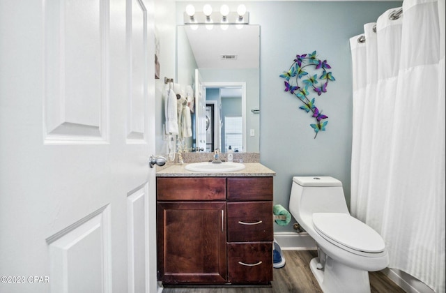 bathroom featuring vanity, hardwood / wood-style floors, and toilet