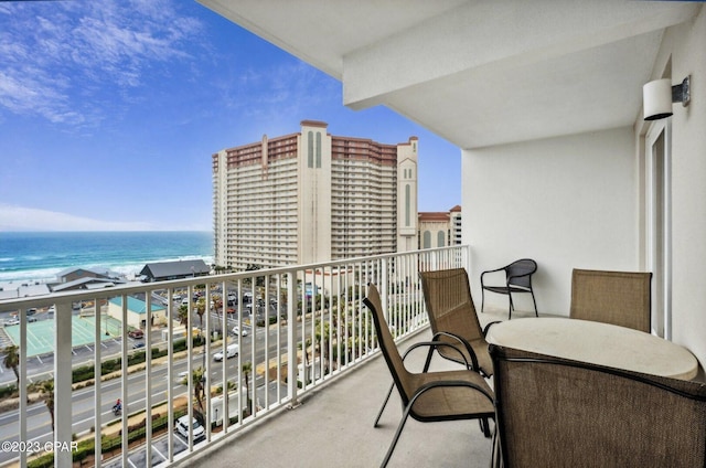 balcony with a water view and a view of the beach