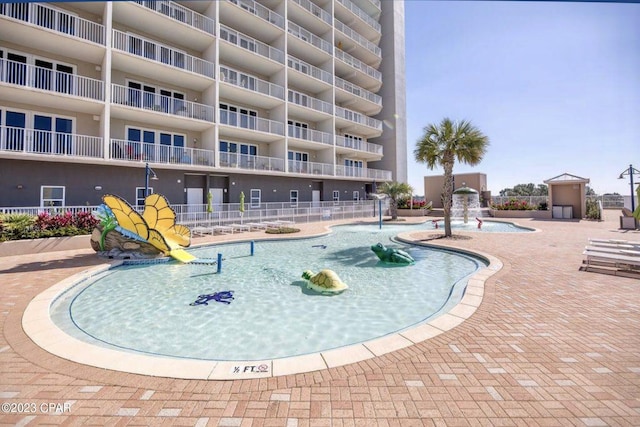 view of swimming pool with pool water feature and a patio area