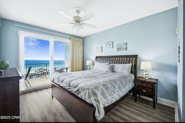 bedroom featuring hardwood / wood-style flooring, a water view, access to exterior, and ceiling fan