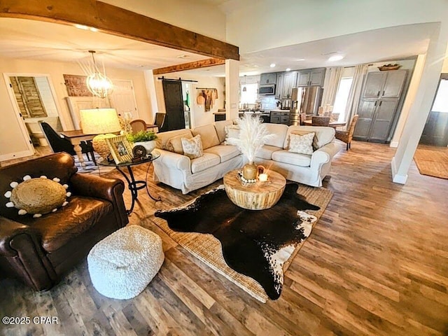 living room featuring hardwood / wood-style floors, a barn door, and beam ceiling